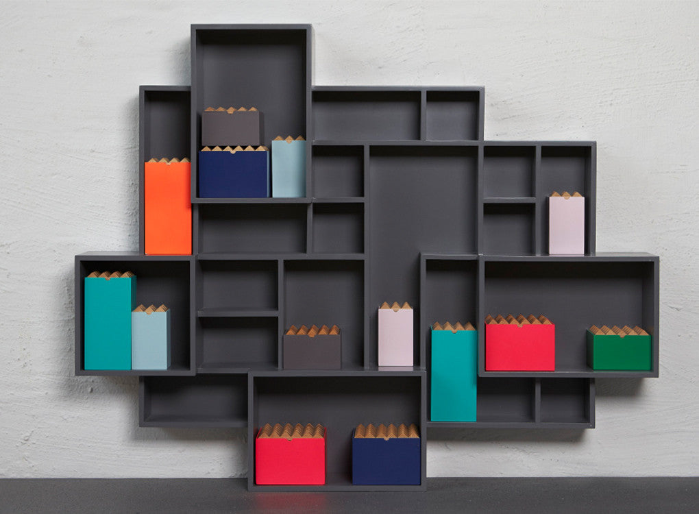 Colourful wooden pyramid storage boxes sitting on a shelf